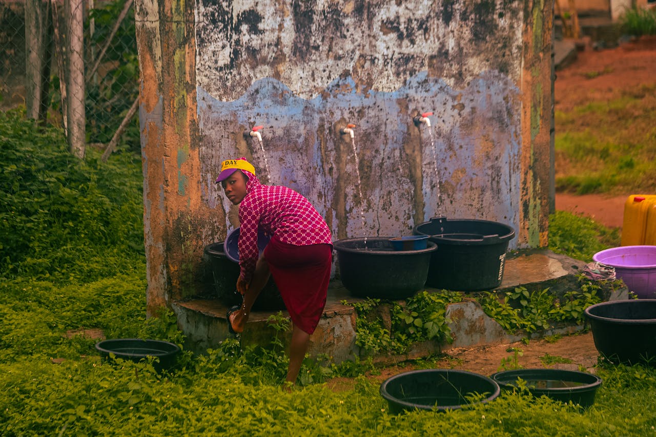 Woman collecting water in a rural Nigerian village, reflecting local life and sustainability.